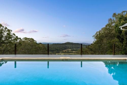 a swimming pool with blue water and a fence at The Farm On Razorback Ridge in Montville