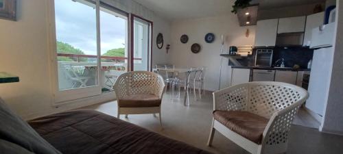Il comprend un salon avec un lit et des chaises ainsi qu'une cuisine. dans l'établissement LOCBASQUE COM Appartement Résid Bidart Plage , classé meublé de tourisme 3 étoiles, à Bidart