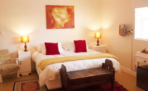 sypialnia z łóżkiem z czerwonymi poduszkami w obiekcie Dolphin Inn Guesthouse w Kapsztadzie