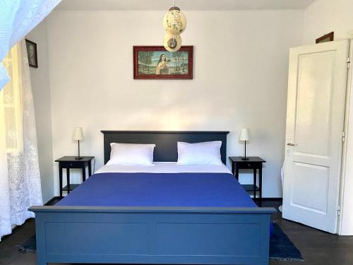 een blauw bed in een slaapkamer met 2 tafels bij Family house Bacalja in Preko
