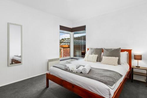 - une chambre avec un grand lit et une fenêtre dans l'établissement Spectacular Views - 5 Bedroom House and Unit - Free Parking - Free WIFI, à Sandy Bay