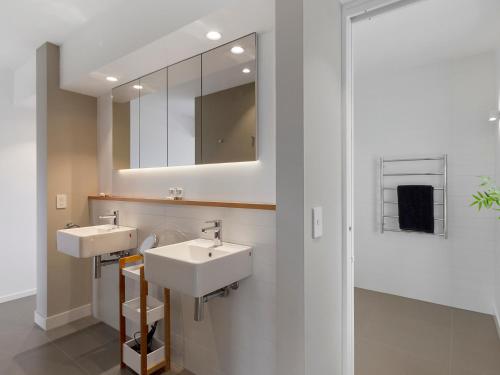La salle de bains est pourvue de 2 lavabos et d'un miroir. dans l'établissement Spectacular Views - 5 Bedroom House and Unit - Free Parking - Free WIFI, à Sandy Bay