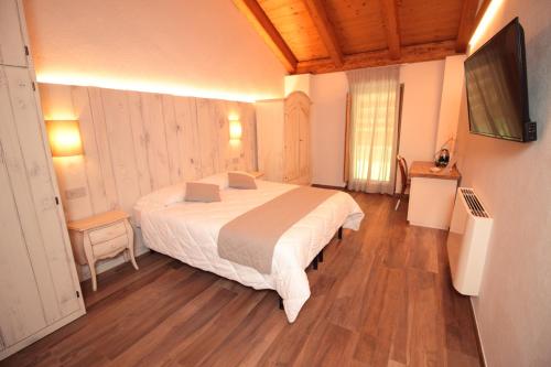 a bedroom with a bed and a television in it at Agr. Cascina Fabbrica in Fossano