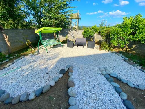 a gravel patio with a bench and a playground at Hotel Orange Kutaisi in Kutaisi