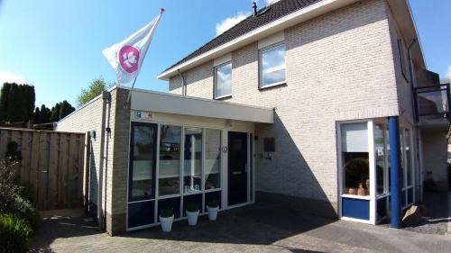 a building with a flag on top of it at Appartement Mijn Ouders Bed en Breakfast Emmeloord in Emmeloord
