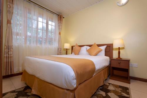 een slaapkamer met een groot bed en een raam bij The Cycads Suites in Nairobi