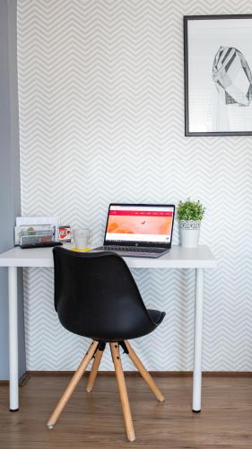 a desk with a laptop computer on top of it at Guest House Family in Kanjiža