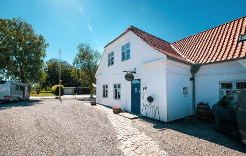 a white building with a car parked in front of it at Tylstrup Kro og Motel in Tylstrup