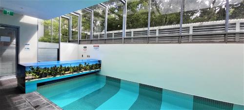 a swimming pool in a building with a large window at beautiful apartment 100mts near the beach in Port Melbourne in Melbourne