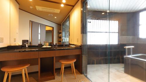 a bathroom with two stools and a sink and a shower at Arima Onsen Taketoritei Maruyama in Kobe