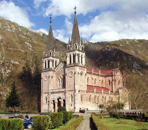 an old church with two towers on a mountain at Casa de Aldea El Frade in Ribadesella