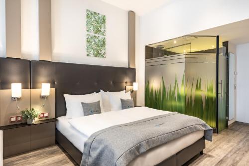 una camera con un grande letto e un grande specchio di Select Hotel City Bremen a Brema