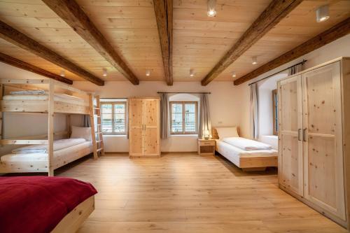 a bedroom with bunk beds and wooden ceilings at Unterlanpacher Historic Refugium in Laces
