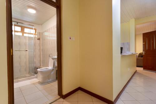 a bathroom with a toilet and a shower in it at The Cycads Suites in Nairobi