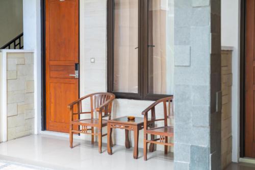 two chairs and a table in front of a door at RedDoorz Plus Syariah @ Jalan Dokter Wahidin Bojonegoro in Bojonegoro