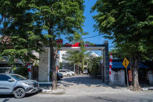 a street with cars parked in front of a garage at RedDoorz Plus Syariah @ Jalan Dokter Wahidin Bojonegoro in Bojonegoro