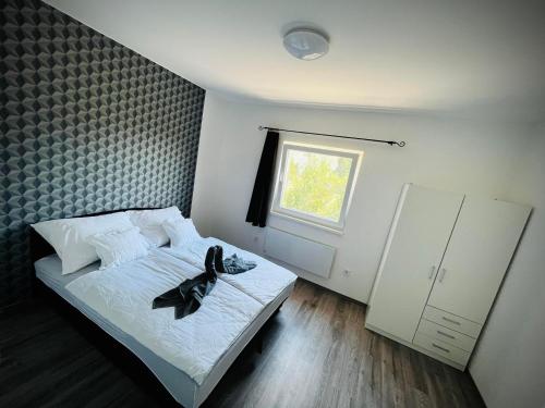 1 dormitorio con cama y ventana en Évi Vendégház Dunakanyar, en Pilismarót