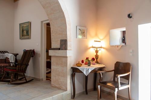 un comedor con mesa y 2 sillas y una habitación con un arco en Villa sitanos, en Sítanos