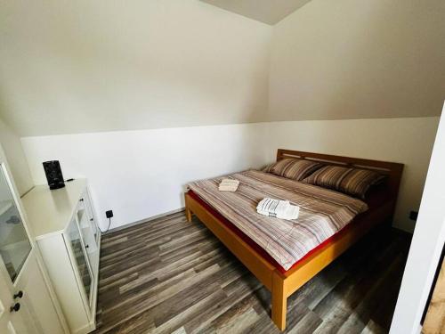 Schlafzimmer mit einem Bett und Holzboden in der Unterkunft Příjemný podkrovní byt s parkováním na pozemku. in Tršice