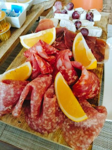 a cutting board with shrimp and oranges and other foods at ANTICA RESIDENZA TOSCANA in Dumbrăviţa
