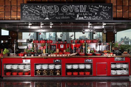 a red oven with a blackboard in a restaurant at SO BANGKOK - SHA Extra Plus in Bangkok