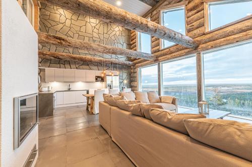 a living room with a large couch and windows at Fort Aurora in Levi