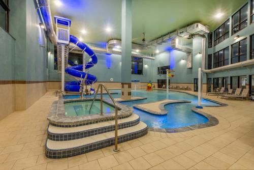 a swimming pool with a slide in a building at Holiday Inn Express Hotel & Suites Erie an IHG Hotel in North East