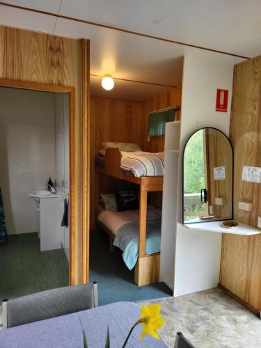 a room with a bunk bed and a mirror at Queenstown Copper Country Cabins in Queenstown