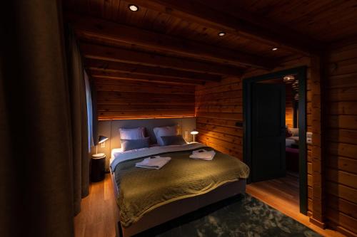 a bedroom with a bed in a room with wooden walls at Harz-Urlaubs-Alm Hotel & Ferienhäuser in Clausthal-Zellerfeld