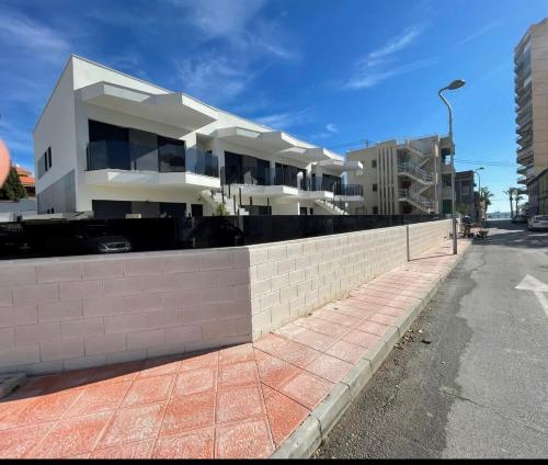un grande edificio bianco sul lato di una strada di Beach bungalow with swiming pool and long terrace a San Javier