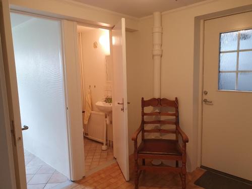 a bathroom with a wooden chair and a sink at 50 m till bad i centrala Skärhamn in Skärhamn