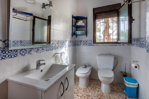 Un baño con lavabo, inodoro y espejo. en Las Pedrizas, en Pilar de la Horadada