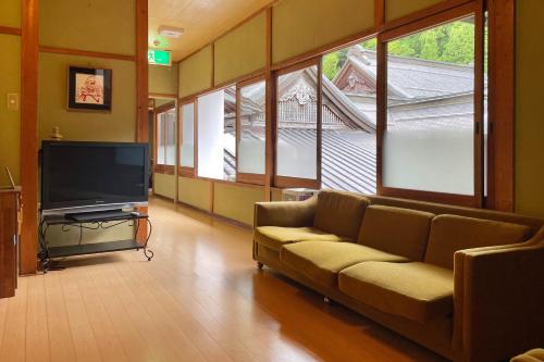 a living room with a couch and a flat screen tv at 高野山 宿坊 宝城院 -Koyasan Shukubo Hojoin- in Koyasan