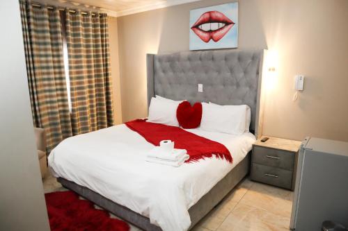 a bedroom with a large bed with a red blanket at Gold Crown International Hotel With Complementary Breakfast and WiFi in Johannesburg