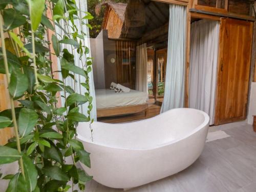 a bath tub sitting in the middle of a room at La Siesta bungalows & Cuisine in Gili Islands