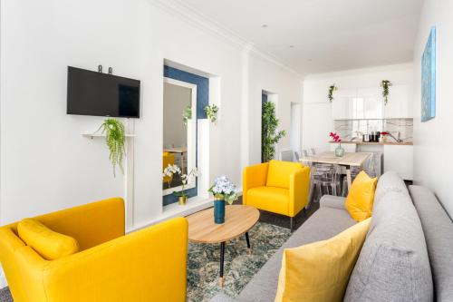 salon z żółtymi krzesłami i kanapą w obiekcie Cosy 2 bedrooms apartment with bathrooms - Louvre w Paryżu