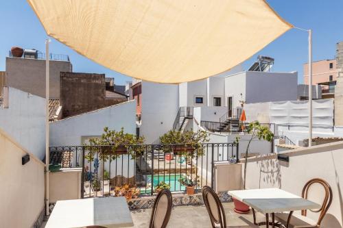 un patio con mesas y sillas en el balcón en Morfeo Charming Rooms & Relax, en Avola