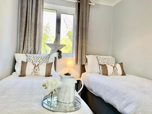 um quarto com 2 camas e uma janela em Charming 2 Bedroom Bungalow with open plan living em Felixstowe