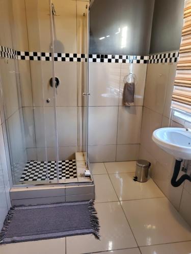 un baño con ducha y lavabo en Beloved Lodge, en Kimberley