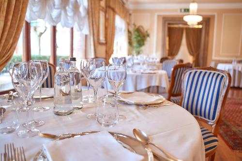 una mesa con copas de vino en un mantel blanco en Hotel Villa Il Patriarca, en Chiusi