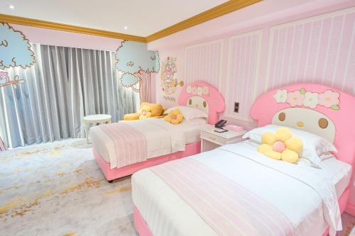 a pink and white bedroom with two beds and teddy bears at Grand Hi Lai Hotel in Kaohsiung