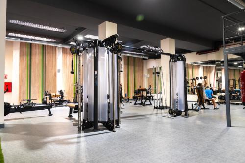 un gimnasio con un montón de equipamiento en una habitación en Hotel Familia Conde, en Huelva