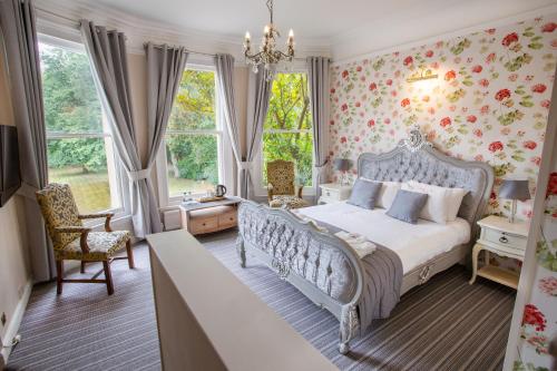 Woodland Manor Hotel في بيدفورد: غرفة نوم مع سرير وورق جدران