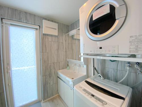 een kleine badkamer met een wastafel en een spiegel bij グランディオーソ沖縄プールヴィラ恩納6 in Onna