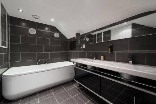 a bathroom with two sinks and a bath tub at The Clarence Boutique Rooms in Portsmouth