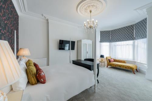 a white bedroom with a bed and a living room at The Clarence Boutique Rooms in Portsmouth