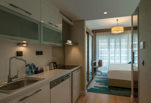 a kitchen with a sink and a bed in a room at The Superior Living Batışehir in Istanbul