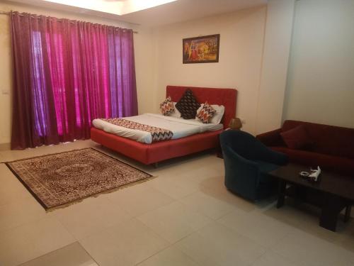 ein Wohnzimmer mit einem Bett und einem Sofa in der Unterkunft HOTEL THE AM BLISS in Gurgaon