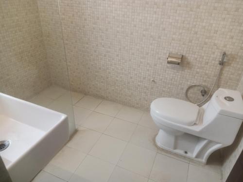 een badkamer met een toilet, een wastafel en een bad bij HOTEL THE AM BLISS in Gurgaon