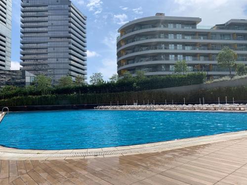 a large blue swimming pool in front of some buildings at The Superior Living Batışehir in Istanbul